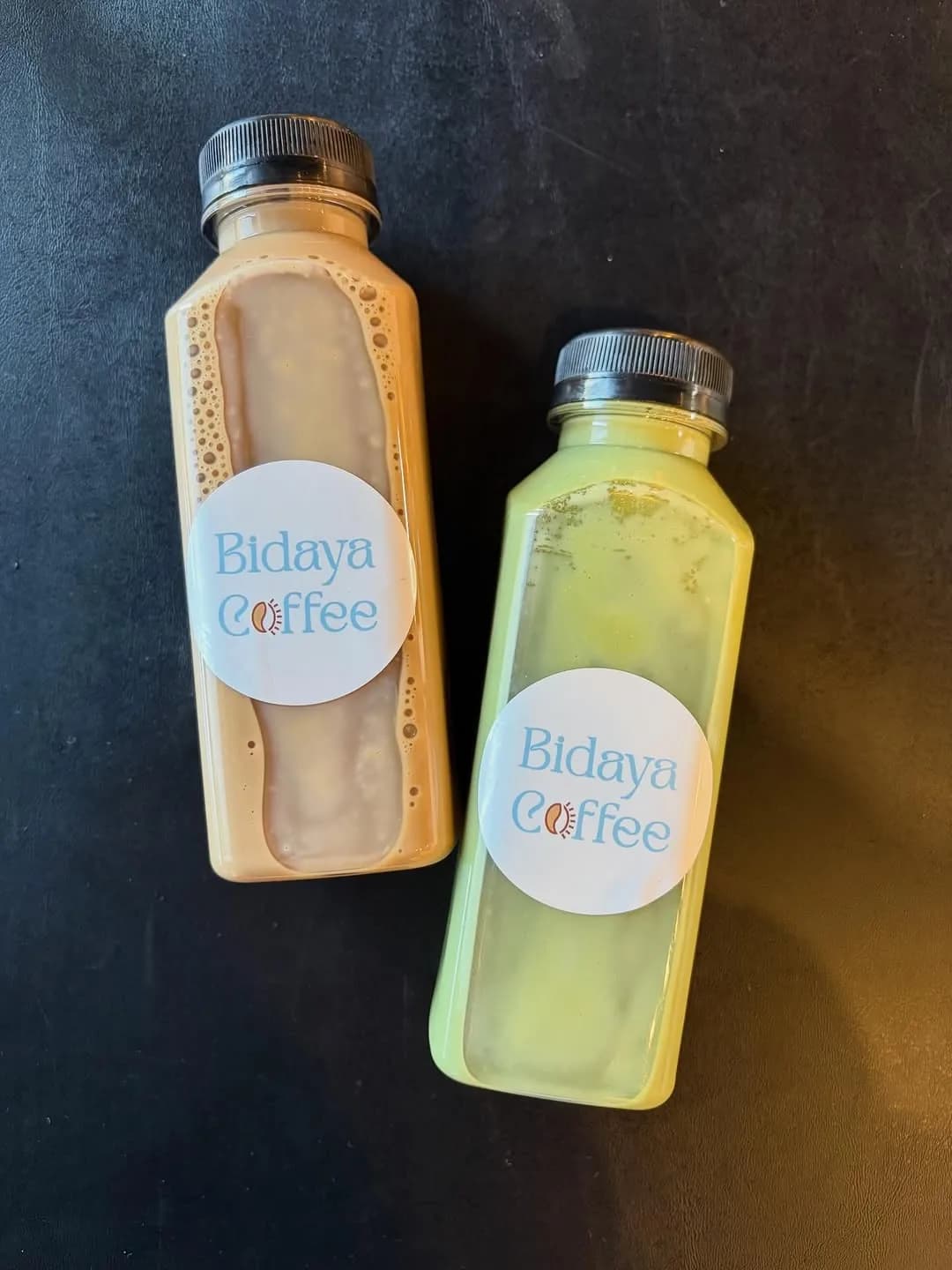 Two Bidaya Coffee bottled lattes, one coffee and one matcha, with branded labels